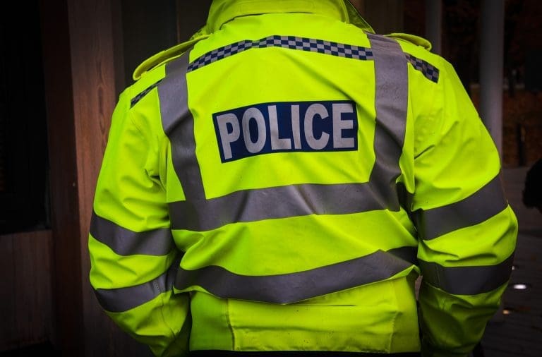 Police officer in hi-vis jacket from behind