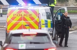 Police van with officer at scene